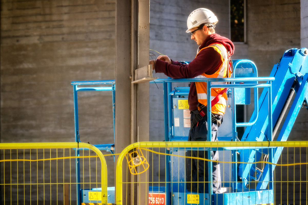 Man performing electrical work in a cherry picker